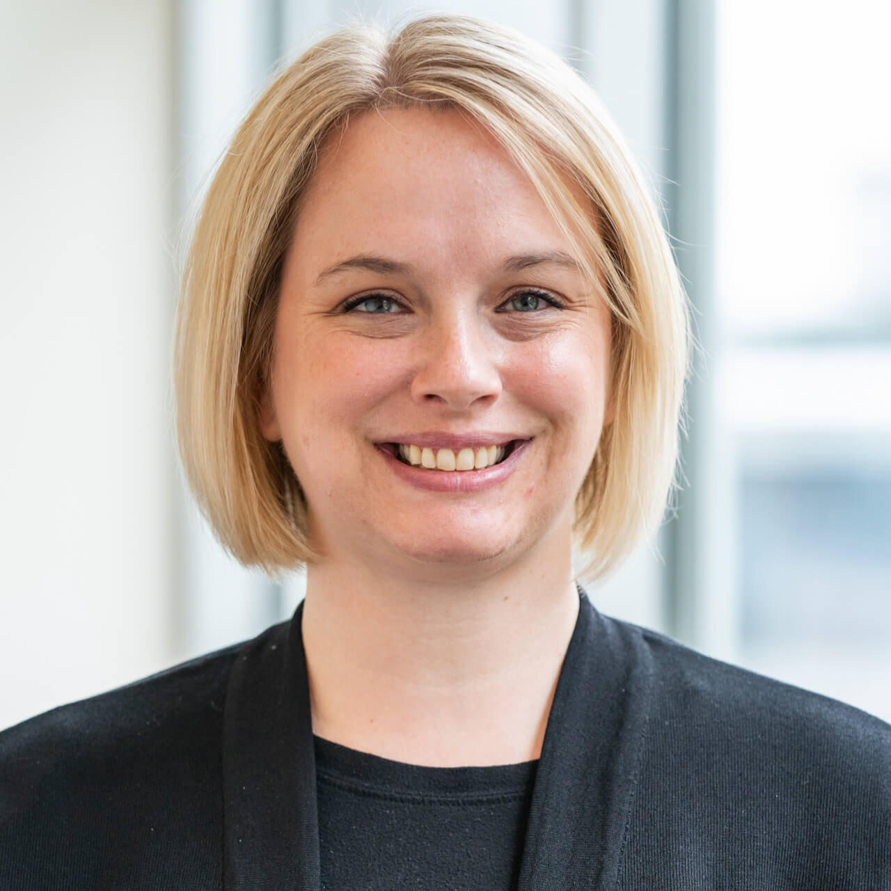Portrait of smiling blonde woman in black blazer