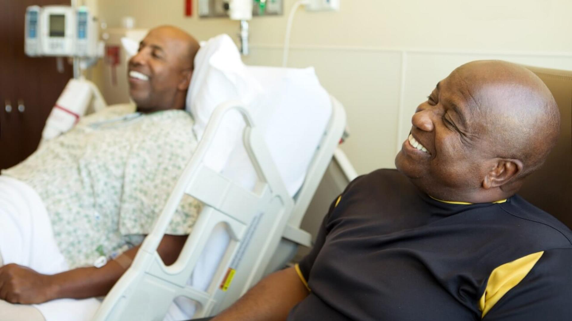 Patient in hospital bed shares a light moment with supporter