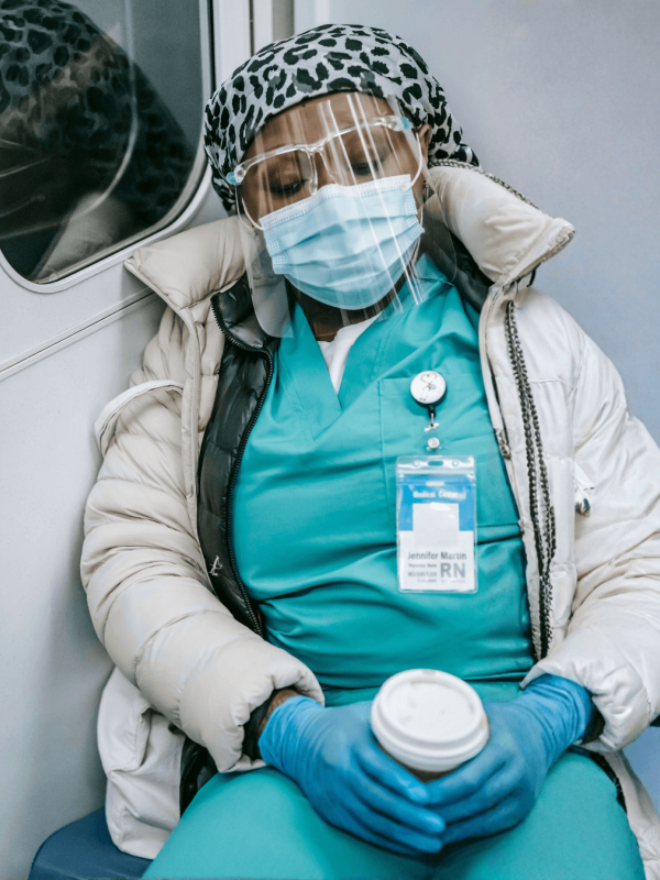 Masked healthcare worker slumps on public transit