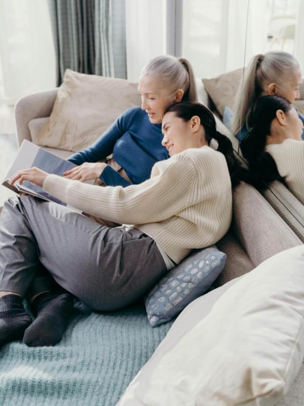 Two people lean together over photo album