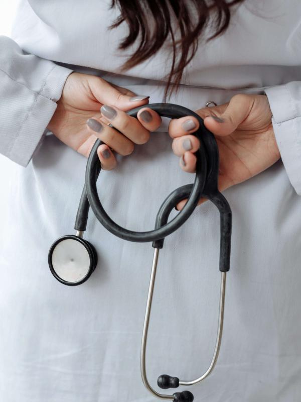Healthcare professional in white coat holds stethoscope