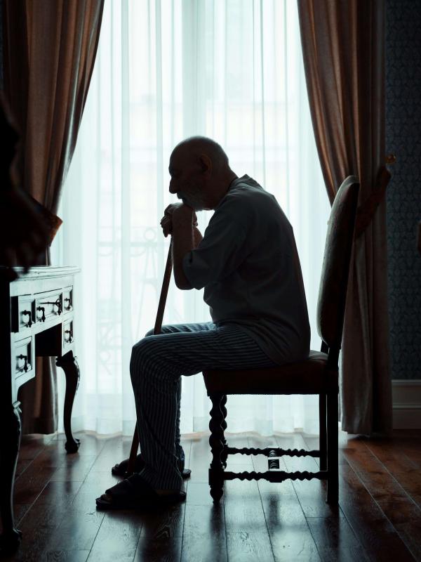 Older adult sitting alone in reflection