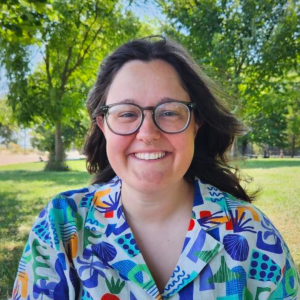 Smiling person outdoors wearing colorful patterned shirt
