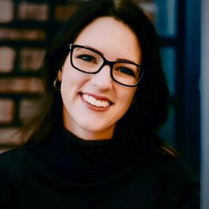 Smiling woman with glasses and dark hair