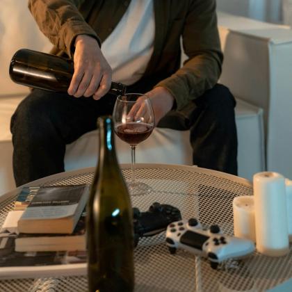 Person pours wine beside coffee table