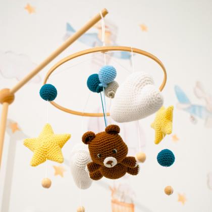 Handmade crib mobile hangs above nursery crib