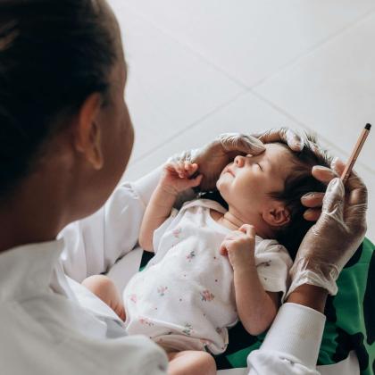 Healthcare professional supports newborn during exam