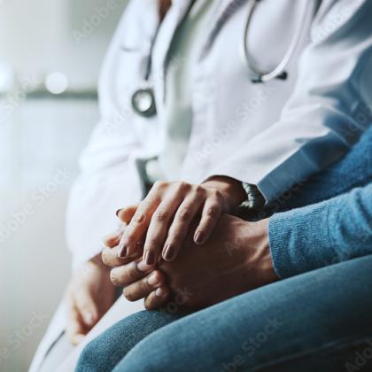 Healthcare professional holding patient’s hands in support