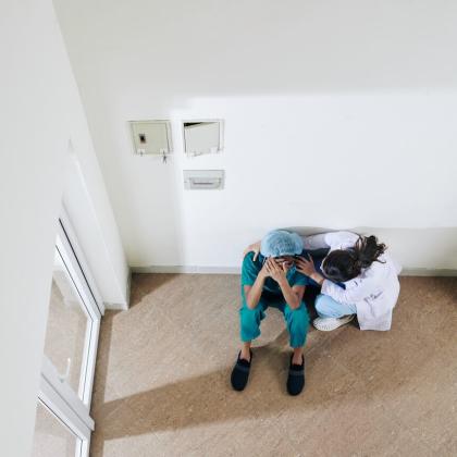 Overhead view of clinician comforting distressed colleague